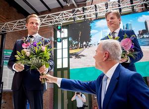 CDA-partijvoorzitter Rutger Ploum (m.) reikt bloemen uit aan de nieuwe partijleider Hugo de Jonge (l.) Rechts diens tegenkandidaat, Kamerlid Pieter Omtzigt. beeld ANP, Sem van der Wal