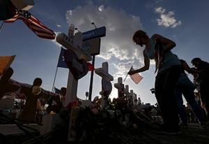 Een vrouw plaatst een Amerikaanse vlag in de buurt van de plaats waar zaterdag 22 mensen werden doodgeschoten. beeld EPA, Larry W. Smith