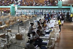 Telling van stemmen in de Anthony Nesty Sporthal in Paramaribo, woensdag. De verkiezingen in Suriname verliepen behoorlijk chaotisch, de officiele uitslag is nog niet bekend. beeld ANP, Ranu Abhelakh