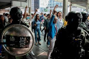 De oproerpolitie versperde betogend kantoorpersoneel vrijdag de doorgang bij een protest in Hongkong. beeld AFP