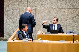 Minister De Jonge (r.) steekt een dikke duim op naar minister Grapperhaus (m.) als die na een korte ondervraging door de Kamer de vergaderzaal weer verlaat. beeld ANP, Bart Maat