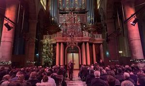Sander van Marion vertelt de aanwezigen in de Rotterdamse Laurenskerk over de werkzaamheden van concertorganisator Pieter van der Ploeg. beeld www.nieuwjaarsconcerten.nl