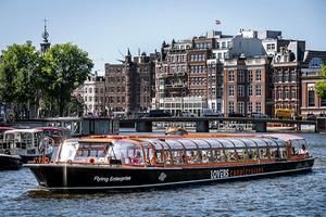 Toeristen op een rondvaartboot in Amsterdam. beeld ANP, RAMON VAN FLYMEN