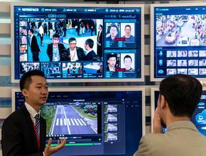 Een medewerker van het Chinese internetbedrijf Huawei in Shenzhen demonstreert technologie voor gezichtsherkenning. beeld EPA