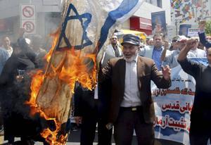 Volgens de Iraanse ”revolutieleider” Khamenei „impliceert de oproep tot liquidatie van de staat Israël niet het uit de weg ruimen van het Joodse volk.” Foto: Iraniërs verbranden een Israëlische vlag tijdens een parade in Teheran tegen het Israëlische gezag over Jeruzalem. beeld AFP
