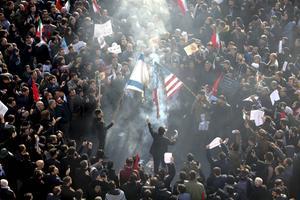 Iraniërs verbrandden maandag in Teheran Amerikaanse en Israëlische vlaggen tijdens de uitvaartplechtigheid voor de geliquideerde generaal Qassem Soleimani. De topofficier werd dinsdag in zijn geboorteplaats Kerman begraven. beeld AFP, Atta Kenare
