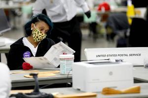 Medewerkers van een stembureau in Detroit, Michigan, waren woensdagavond nog met man en macht aan het tellen. beeld AFP, Jeff Kowalsky