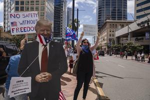 Amerikanen protesteren in San Diego tegen beperkende maatregelen van de overheid. beeld AFP, Ariana Drehsler
