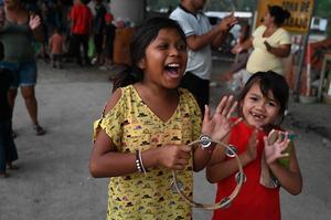 Kinderen spelen onder een brug na een orkaan huishield in Honduras. Naar verwachting zijn 1,8 miljoen kinderen getroffen door het noodweer in de arme regio. beeld AFP, Orlando Sierra