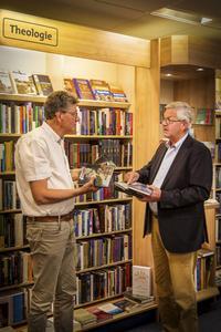 Kees den Hertog (r.) bij boekhandelaar Frits Hardeman in Ede: „En er zal altijd worden gelezen, daar ben ik van overtuigd.” beeld RD, Henk Visscher
