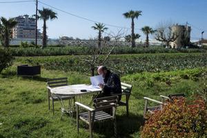 Een werknemer bekijkt wat documenten bij een biologische landbouwcoöperatie in Barcelona. De bedrijvigheid in de Spaanse tuinbouw staat momenteel onder druk vanwege de coronacrisis. beeld EPA, Enric Fontcuberta