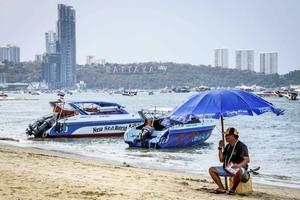 Het toerisme is een van de sectoren die hard wordt getroffen door het coronavirus. Op het strand van de Thaise kuststad Pattaya wacht een speedbootbestuurder tevergeefs op zijn Chinese toeristen. beeld AFP, Mladen Antonov