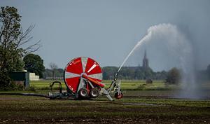 Een boer beregent zijn akker. beeld ANP