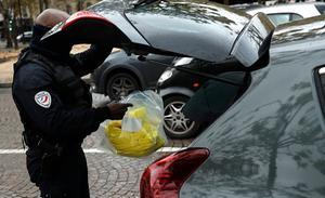 Een Franse politieagent neemt gele hesjes in beslag in Parijs. beeld EPA