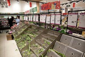 Lege schappen in een supermarkt in de Chinese stad Wuhan. Inwoners van de stad zijn in verband met het coronavirus aan het hamsteren geslagen. beeld EPA