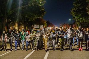Demonstranten in Minneapolis lopen arm in arm. beeld AFP, Kerem Yucel