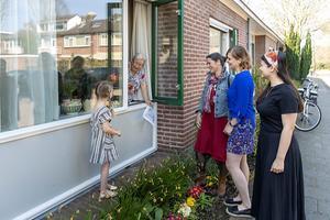 De 86-jarige Cornelia Smit-Ligtenberg uit Vinkeveen krijgt raambezoek van haar 5-jarige achterkleindochter Avia (5), schoondochter Christine (50) en kleindochters Kyra (23) en Sara-Maria (24, rechts op de foto) beeld RD, Henk Visscher