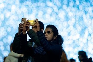 Een vrouw maakt een foto met haar smartphone. beeld AFP