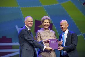 Piet Fortuin (r.), voorzitter van CNV-Vakmensen, overhandigt met algemeen secreatris Johan Slok een jubileumboek aan koningin Máxima tijdens het jubileumcongres van CNV Vakmensen in Nieuwegein. beeld ANP, Frank van Beek