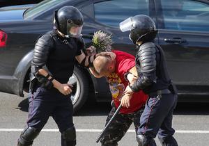 Politiemannen arresteren een man die bloemen wilde neerleggen op de plaats waar een Wit-Russische demonstrant om het leven kwam, in Minsk, Wit-Rusland. beeld EPA