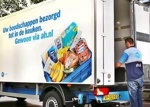 Een medewerker van de Albert Heijn bezorgt een doos met ingrediënten voor een maaltijd. Steeds meer mensen bestellen online, meldde het CBS maandag. beeld ANP, Stephan van den Bos