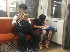 De druk op Japanse kinderen om goede schoolprestaties te leveren is hoog. Foto: in de metro is er nog tijd om huiswerk te maken. beeld Ab Jansen