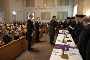 Ds. De Boer ontvangt de doctorsbul in een volle Barnabaskerk in Apeldoorn.  beeld RD, Anton Dommerholt