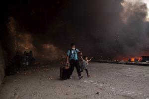 Mensen ontvluchten het brandende vluchtelingenkamp Moria op Lesbos. Meer dan 12.000 mannen, vrouwen en kinderen renden in paniek uit containers en tenten naar aangrenzende olijfboomgaarden en velden terwijl vlammen het overvolle, smerige kamp grotendeels verwoestten. beeld AFP, Angelos Tzortzinis