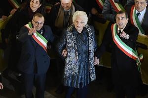 De Italiaans-Joodse senator Liliana Segre (m.) tijdens een solidariteitsbijeenkomst van honderden burgemeesters, december 2019. De bijeenkomst was georganiseerd nadat Segre onder politiebescherming moest worden geplaatst vanwege antisemitische dreiging. beeld EPA, Flavio Lo Scalzo