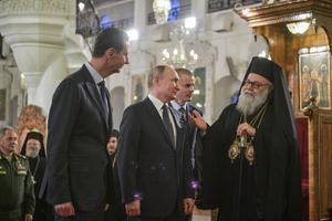 Onderonsje tussen de Syrische president Bashar al-Assad (l.), zijn Russische ambtgenoot Vladimir Poetin (m.) en de Grieks-orthodoxe patriarch Johannes X tijdens een ontmoeting in de Syrische hoofdstad Damascus. beeld TASS, Alexei Druzhinin
