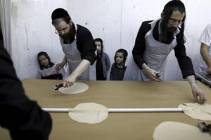 Foto van Pesach (Pasen) vorig jaar: Ultraorthodoxe Joden zijn bezig met de voorbereiding van –ongezuurde– matzes in een bakkerij in de Israëlische stad Bnei Brak. beeld AFP, Menahem Kahana
