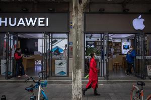 Een pand van Apple en Huawei staan naast elkaar in de Chinese stad Wuhan. beeld EPA