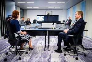 Koning Willem-Alexander neemt deel aan een videoconferentie met buitenlandse ambassades tijdens een werkbezoek aan het 24/7 BZ contactcentrum van Buitenlandse Zaken, dat zich bezig houdt met de repatriëring van reizigers die zijn gestrand door het coronavirus. beeld ANP