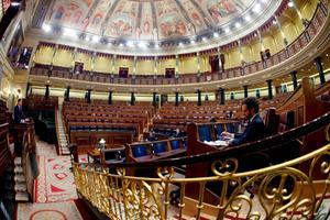 De Spaanse premier Sanchez (l.) sprak donderdag voor een vrijwel leeg parlement over versoepeling van de maatregelen tegen corona. beeld AFP, Mariscal