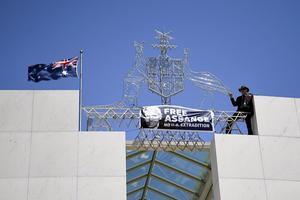 „Julian Assange zit gevangen omdat hij de waarheid openbaarde over onder meer Irak en Jemen. Ook Nederland wilde hem geen politiek asiel verlenen.” Foto: een demonstrant vraagt boven op het parlementsgebouw in het Australische Canberra om de vrijlating van Julian Assange. beeld EPA, Lukas Coch