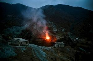 Bewoners in Nagorno-Karabach staken zaterdag hun huizen in brand voordat ze vluchtten naar Armenië. In een dorp in het district Kalbajar dat onder controle van Azerbeidzjan komt, stonden zaterdagmorgen zeker zes huizen in brand. beeld AFP, Alexander Nemenov