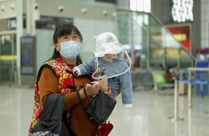 Een Chinese moeder met haar kindje op een treinstation aan de rand van de zwaar getroffen provincie Hubei.​ China heft de meeste beperkingen voor burgers in die regio weer op nu het coronavirus onder controle lijkt. beeld AFP, Noel Celis