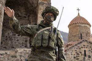 Een Russische soldaat in de tuin van het Dadivankklooster in Kalbajar, Nagorno-Karabach. beeld AFP, Andrey Borodulin