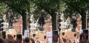 Compilatie van beelden van het omvertrekken van een standbeeld van de 17e eeuwse slavenhandelaar Edward Colston in Bristol. beeld AFP