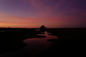 Mont Saint-Michel, een eilandje voor de kust in het noordwesten van Frankrijk tijdens ondergaande zon. beeld AFP