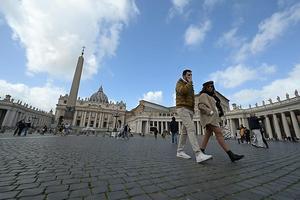 Toeristen lopen vrijdag op een verlaten St. Pietersplein in Rome. beeld AFP, Vincenzo Pinto