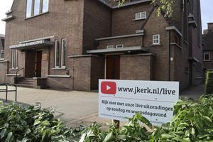 In de tuin van de kerk van de gereformeerde gemeente van Dordrecht kwam een bord met daarop een link naar de livestream op YouTube. beeld G. T. S. de Korte
