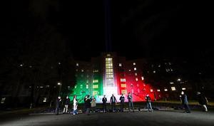 Het Spedali Civiliziekenhuis in de Italiaanse stad Brescia, verlicht in de nationale kleuren, ter nagedachtenis aan de vele coronaslachtoffers die inmiddels in het land te betreuren zijn. beeld EPA, Filippo Venezia