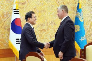 De Zuid-Koreaanse president Moon schudt maandag de hand van de speciale afgezant van de VS voor Noord-Korea, Stephen Biegun. beeld EPA