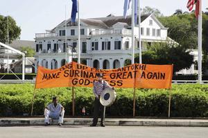Aanhangers van de nieuwe Surinaamse president Chandrikapersad Santokhi, deze week in Paramaribo. Op het spandoek de tekst ”Maak Suriname weer groot.” beeld ANP, Ranu Abhelakh