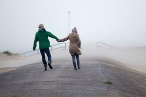 Mensen op de Oosterscheldekering tijdens een herfststorm in 2016. beeld ANP
