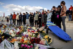 Bij surfclub The Shore op het strand van Scheveningen herdenken mensen de overleden surfers die omkwamen in de golven. Waarschijnlijk werden ze verrast door schuimvorming op de zee. beeld ANP, Sem van der Wal