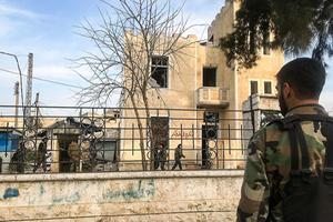 Een Syrische militair inspecteert in Saraqib, in de provincie Idlib, een gebouw dat werd door rebellen werd gebruikt als politiebureau. beeld AFP