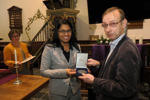 Wethouder Kavita Parbhudayal overhandigt organist Vincent Hildebrandt de Haagse Stadspenning. beeld Pieter Baak