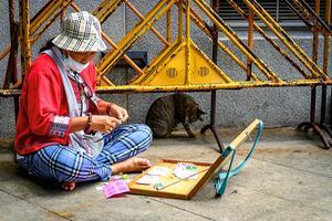 Straatverkopers, zoals deze vrouw in de Thaise hoofdstad Bangkok, zijn uitermate kwetsbaar in perioden van strenge maatregelen tegen het coronacrisis. beeld AFP, Mladen Antonov